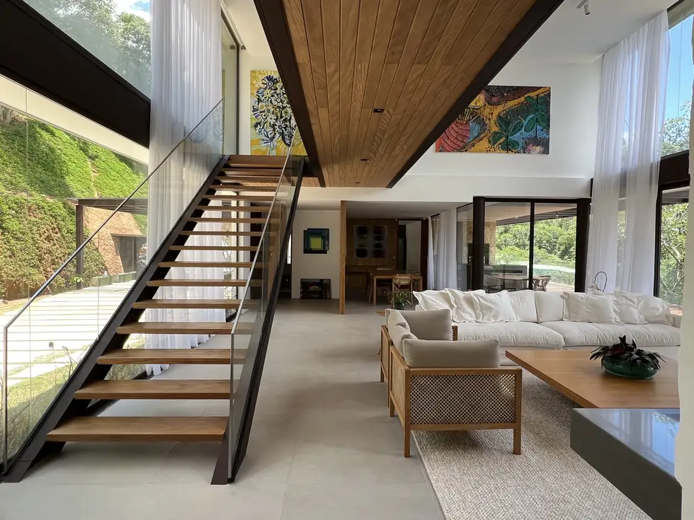 Sala de pé-direito duplo com escada em madeira e aço — NS Engenharia